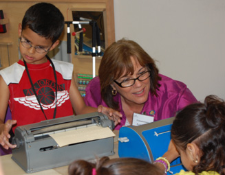Commissioner Bell is shown a Braille letter