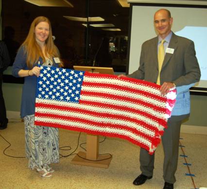 Business card raffle prize winner with prize, a tactile American Flag made by Social Group Activities clients