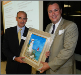 Chairman of the Board Agustin Arellano, Jr. presenting Jose Gonzalez, All Aboard Florida, with a tactile painting made by Social Group Activities 