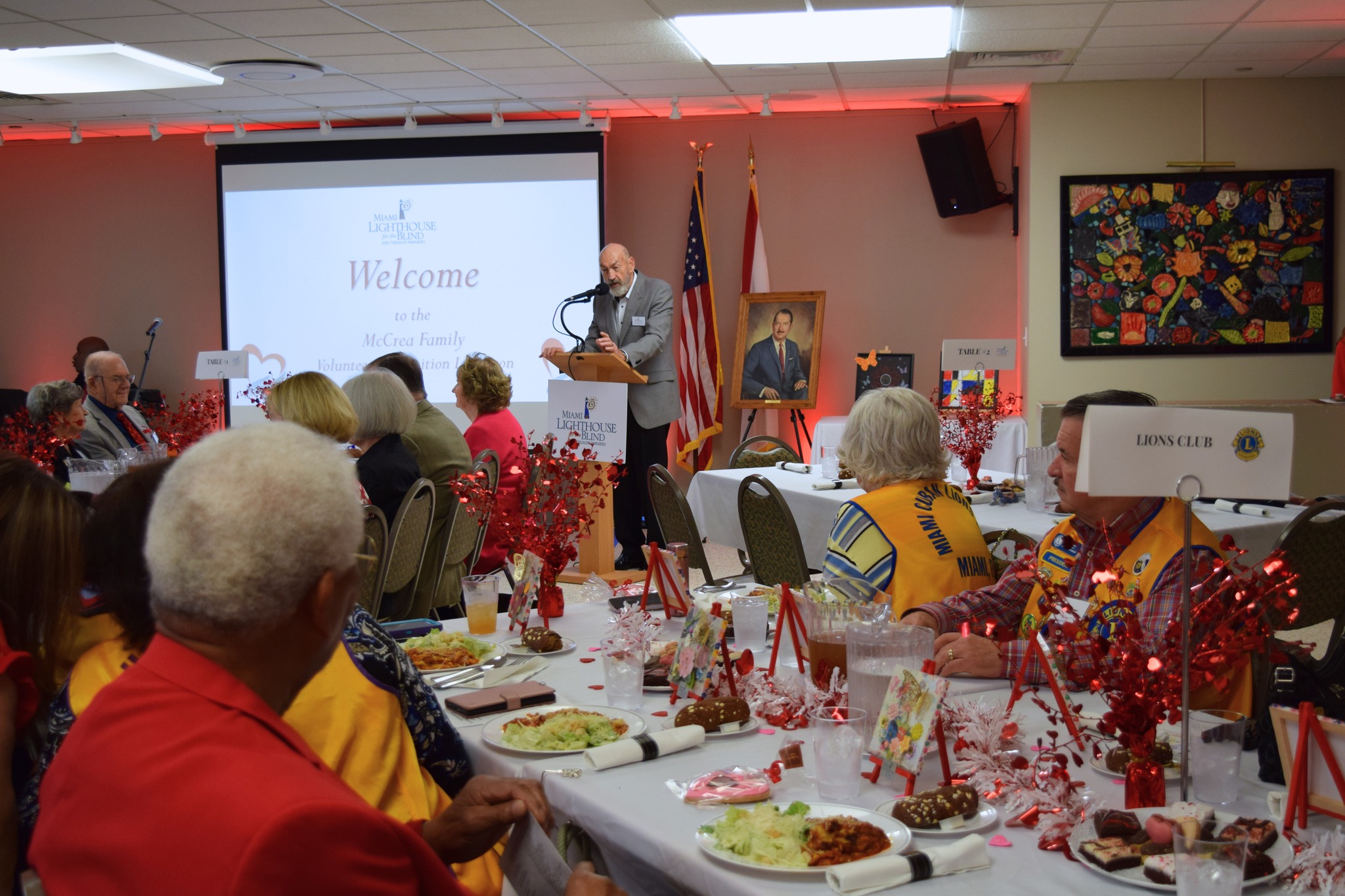 Charles J. Nielson, Secretary of the Board of Directors, warmly welcomes guests with opening remarks at the luncheon.